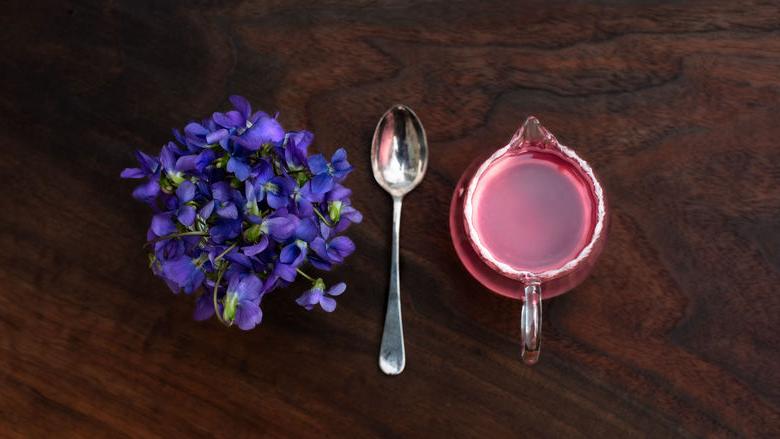 measuring cup, spoon, and flowers on a table 